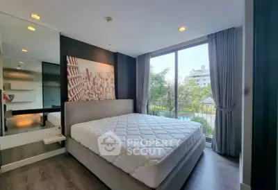 Spacious bedroom with large window and modern decor in a stylish apartment.