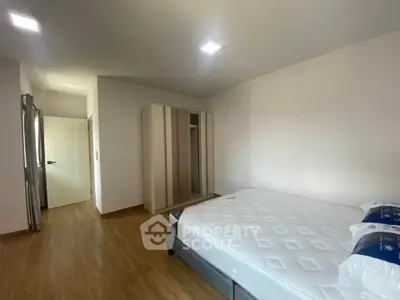 Spacious bedroom with modern wardrobe and comfortable bed in a well-lit apartment.