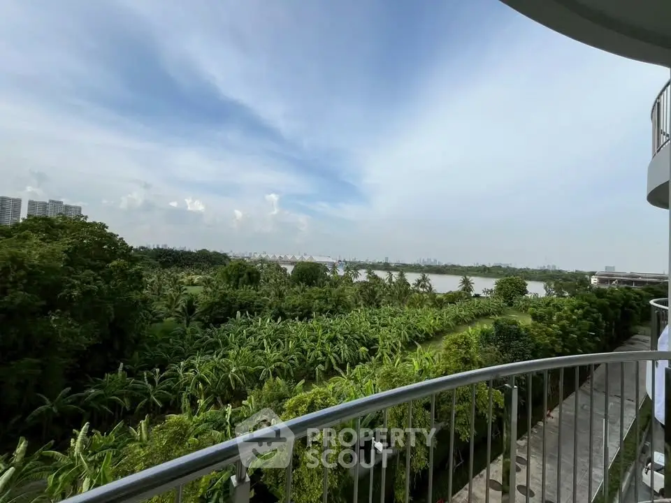 Stunning balcony view overlooking lush greenery and serene river, perfect for nature lovers.