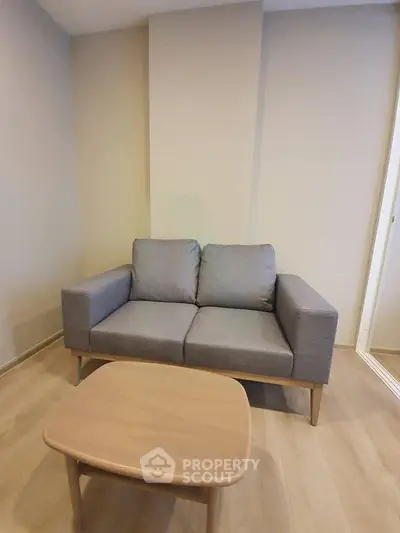 Cozy living room with modern gray sofa and wooden coffee table, perfect for relaxation.