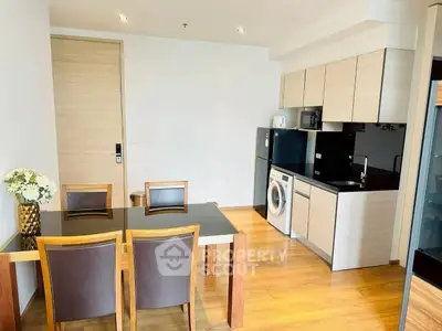 Modern kitchen and dining area with sleek appliances and wooden flooring