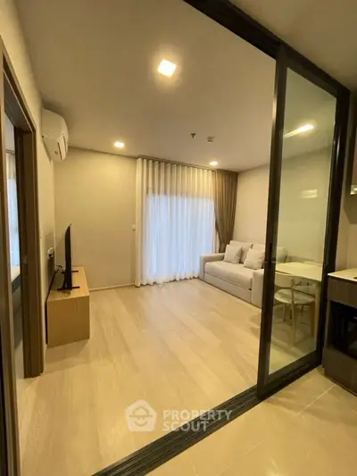 Modern living room with sliding glass doors and cozy sofa, perfect for relaxation.