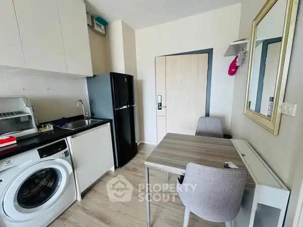 Modern compact kitchen with washing machine and dining area, perfect for urban living.