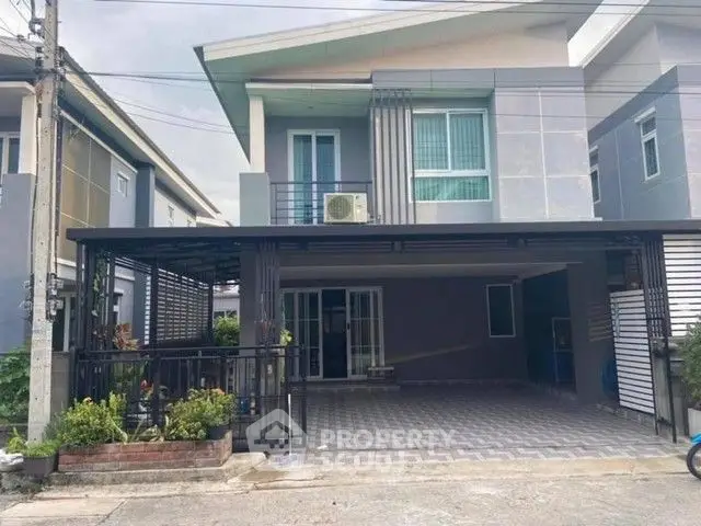 Modern two-story house with spacious driveway and balcony in a suburban neighborhood.
