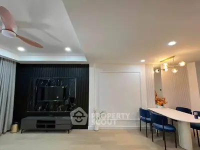 Modern living room with stylish decor and elegant dining area, featuring contemporary lighting and sleek furniture.