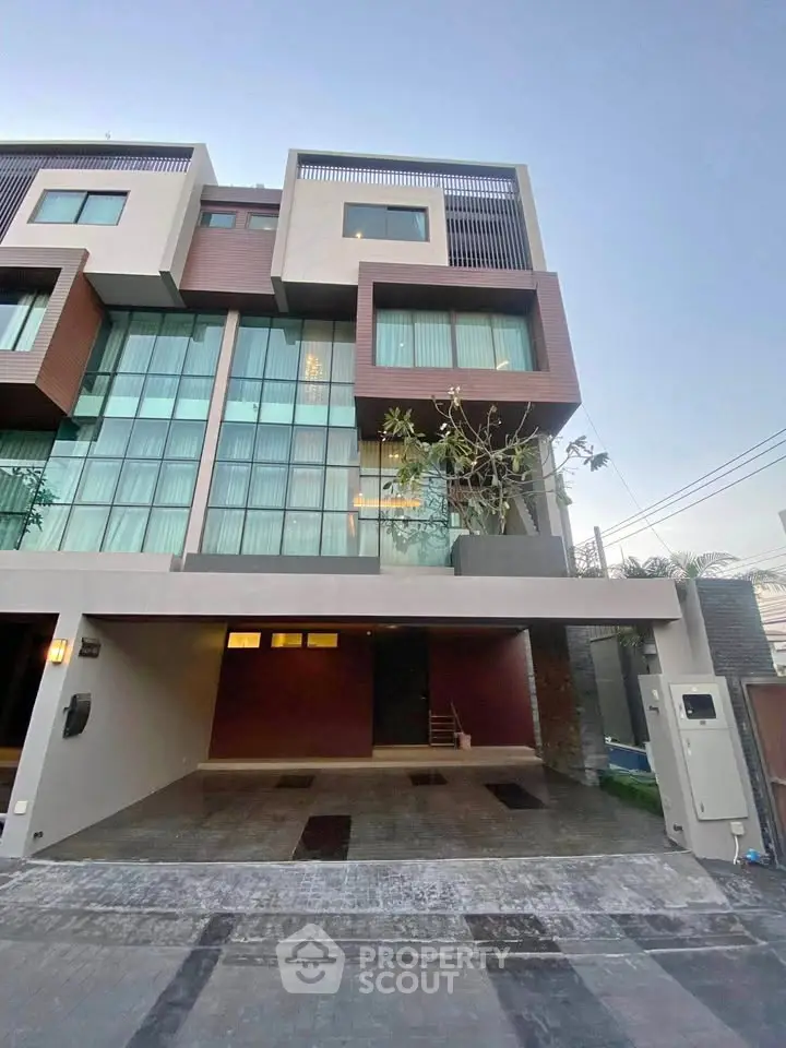 Modern multi-story townhouse with large windows and spacious garage in urban setting.