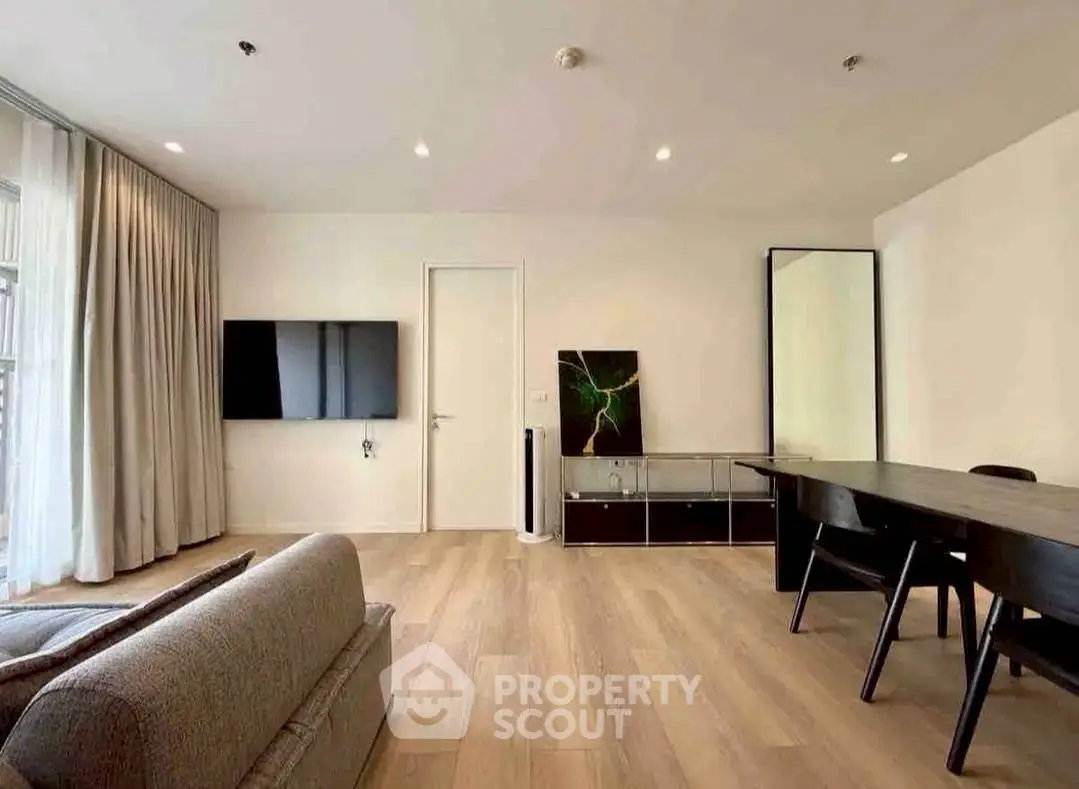 Spacious modern living room with sleek furniture and large TV