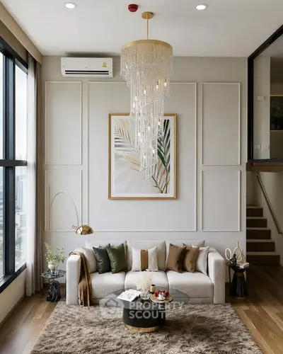 Luxurious living room with elegant chandelier and modern decor, featuring large windows and stylish furniture.