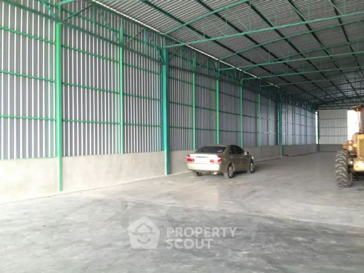 Spacious industrial warehouse with high ceilings and ample parking space.
