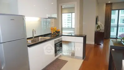Modern kitchen with sleek design and open layout leading to a bright bedroom.