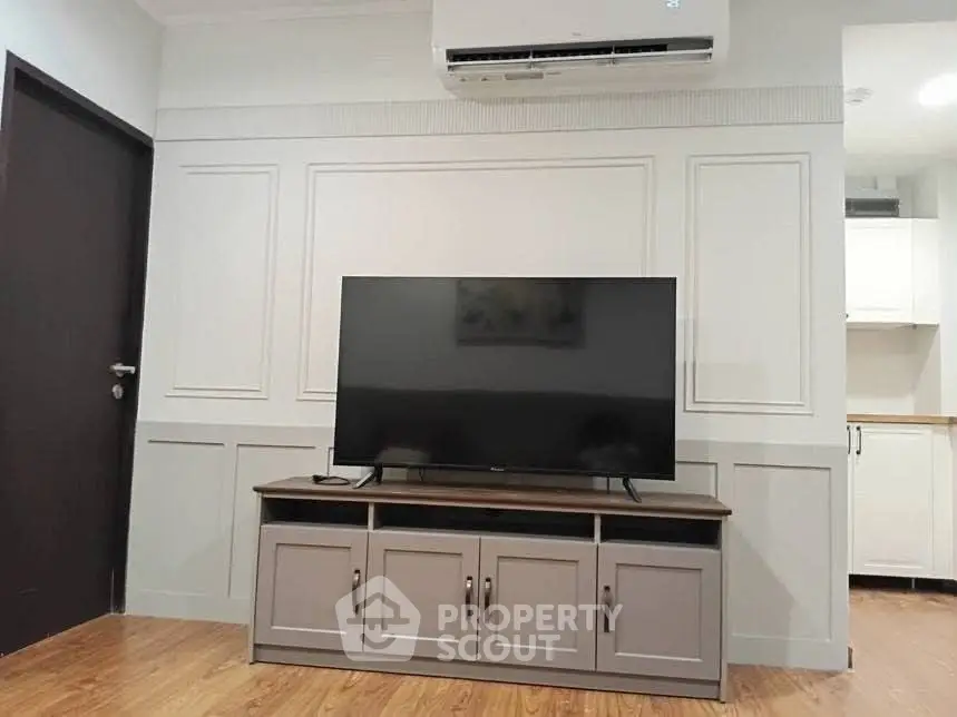 Modern living room with sleek TV setup and air conditioning unit