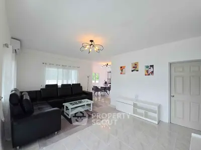 Spacious modern living room with stylish black leather sofa and elegant lighting