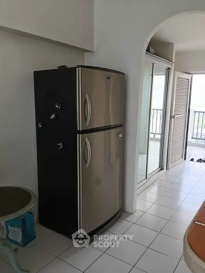 Spacious kitchen with modern fridge and balcony view