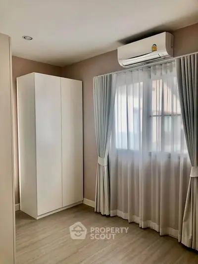 Bright bedroom with air conditioning and elegant curtains in modern apartment.