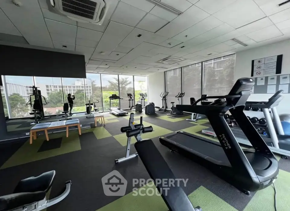 Spacious modern gym with large windows and state-of-the-art fitness equipment.