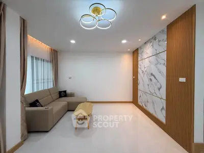 Modern living room with elegant marble accent wall and stylish lighting
