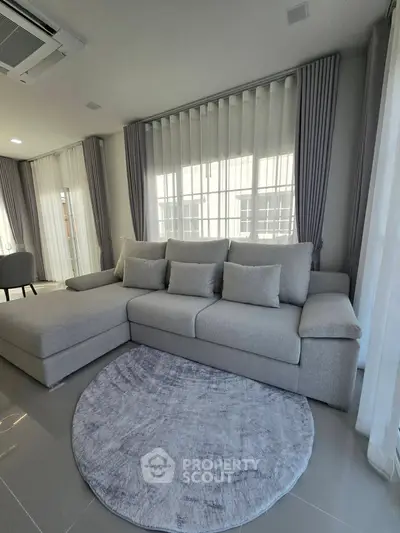 Modern living room with elegant gray sectional sofa and stylish round rug