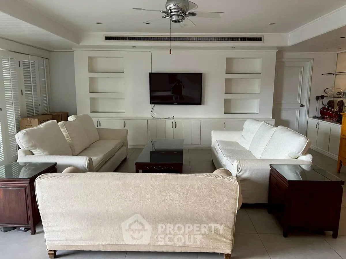 Spacious living room with elegant white sofas and built-in shelving