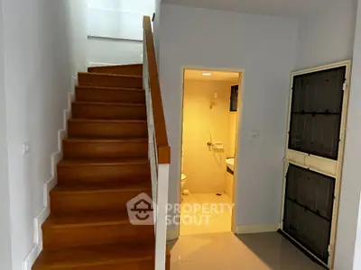Modern interior with wooden staircase and bathroom access, ideal for stylish living.