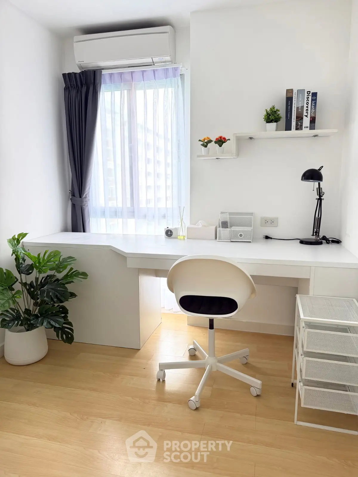 Bright study room with modern desk, chair, and window view in stylish apartment.