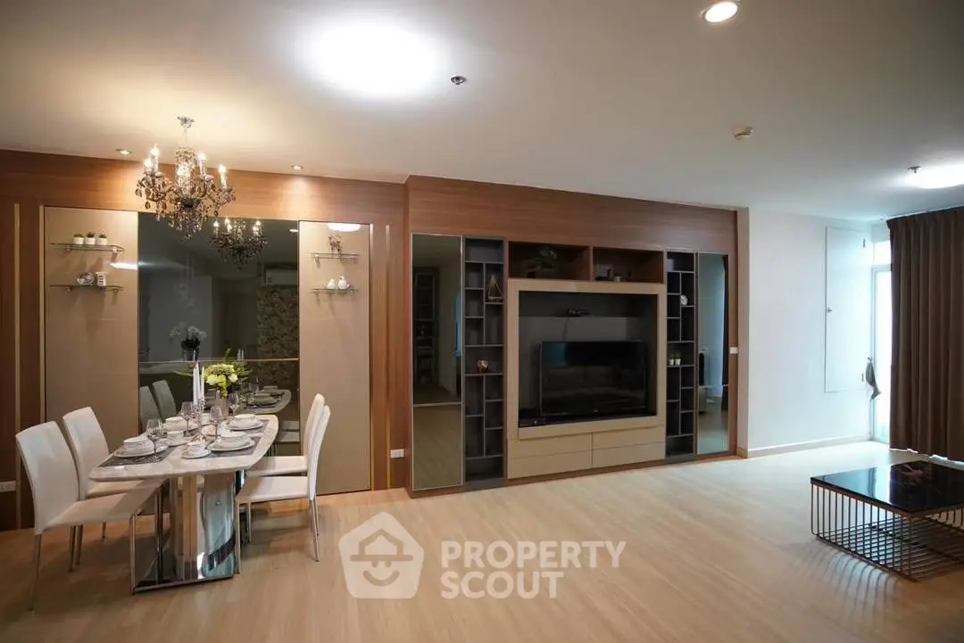 Elegant living room with modern decor, chandelier, and dining area in a spacious open layout.