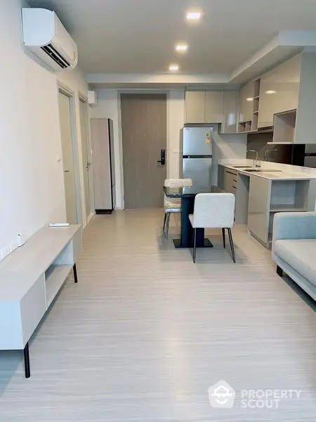 Modern studio apartment with sleek furniture and integrated kitchen, perfect for urban living with a cozy, inviting atmosphere.