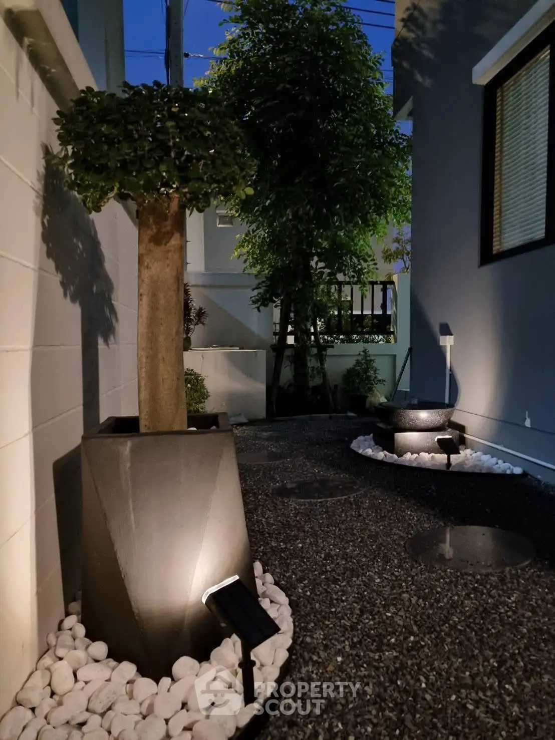Charming garden with modern lighting and elegant potted plants at dusk