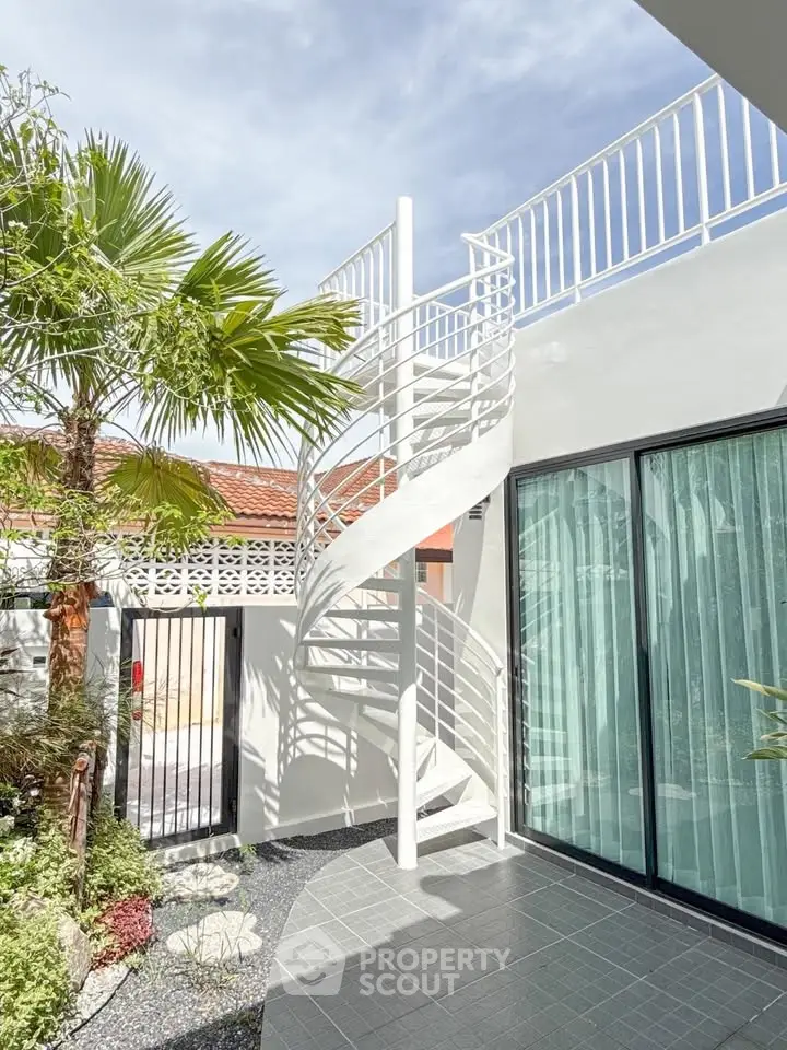 Modern exterior with spiral staircase and lush garden in sunny setting