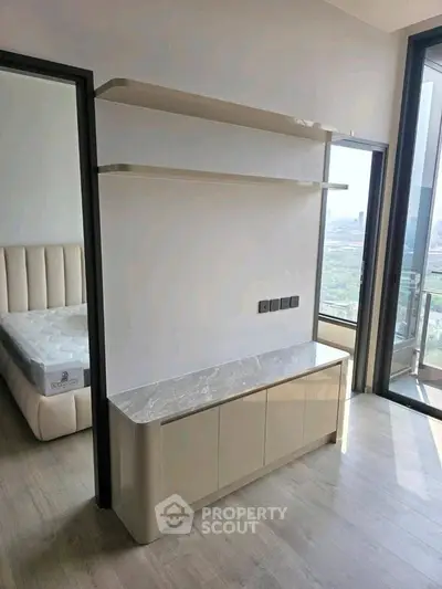 Modern bedroom with sleek storage and balcony view in luxury apartment