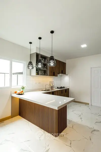 Modern kitchen with sleek design, featuring an open layout and stylish pendant lighting.