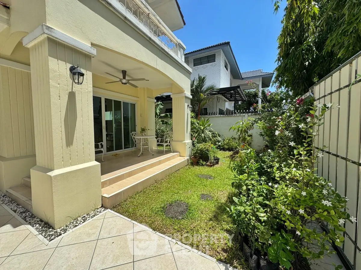 Charming garden view of a modern home with patio and lush greenery, perfect for outdoor relaxation.