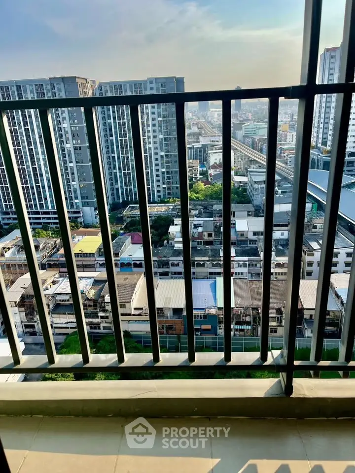 Stunning high-rise balcony view overlooking urban cityscape with modern buildings and clear skies.