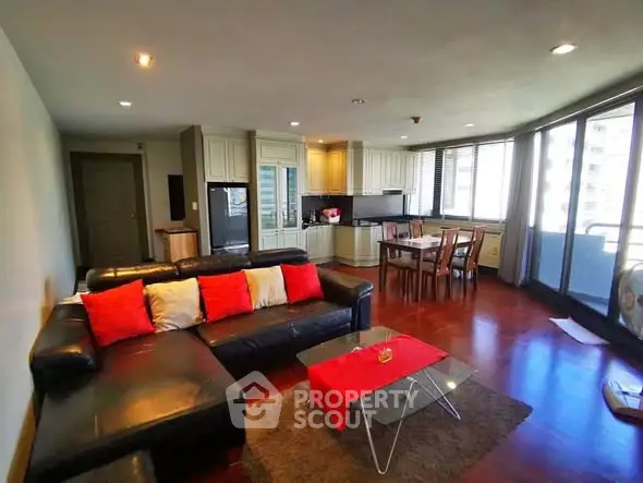 Spacious living room with modern kitchen and dining area in open layout apartment.