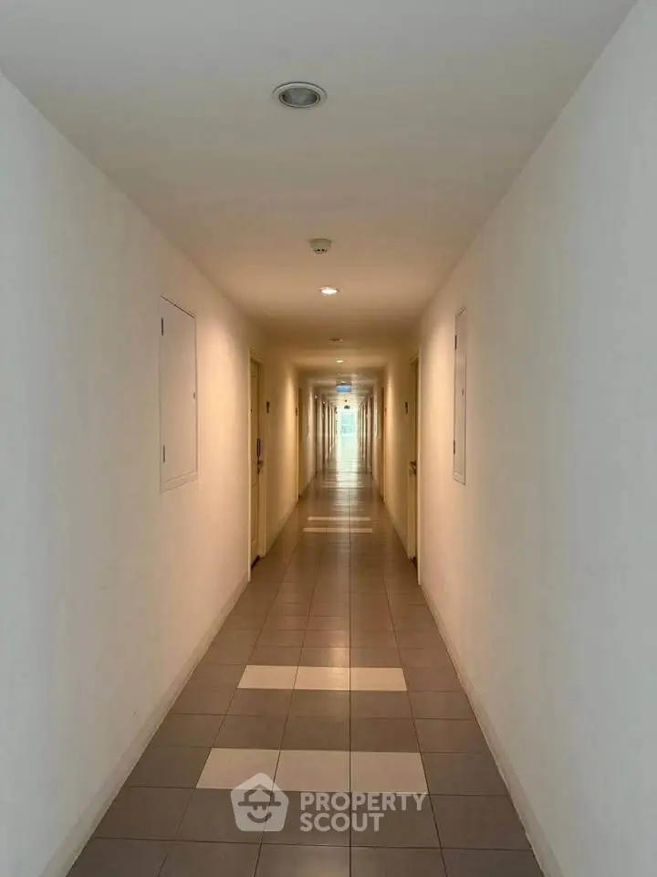 Modern apartment corridor with tiled flooring and bright lighting
