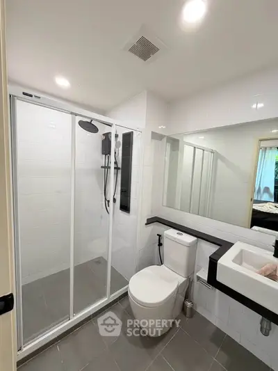 Modern bathroom with sleek shower and stylish fixtures in contemporary home.