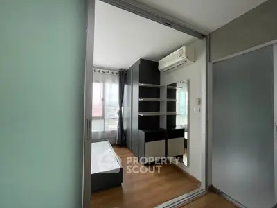 Modern bedroom with sleek design and ample natural light, featuring built-in shelves and air conditioning.
