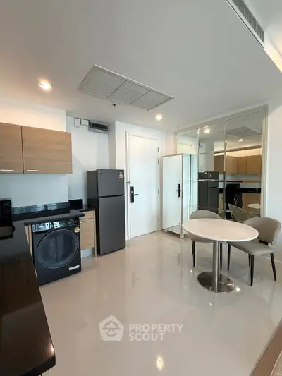 Modern kitchen with sleek appliances and dining area in stylish apartment