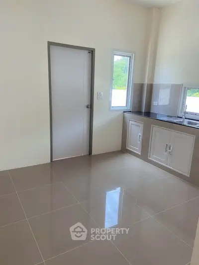 Modern kitchen with sleek cabinetry and ample natural light, perfect for culinary enthusiasts.
