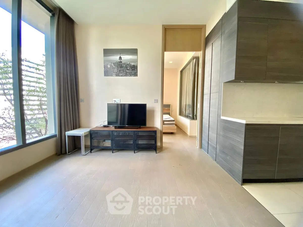 Modern living room with large windows and sleek kitchen design