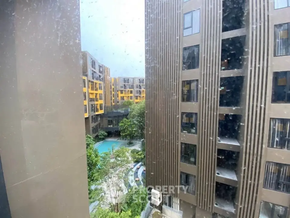 Modern apartment complex with pool view and lush greenery