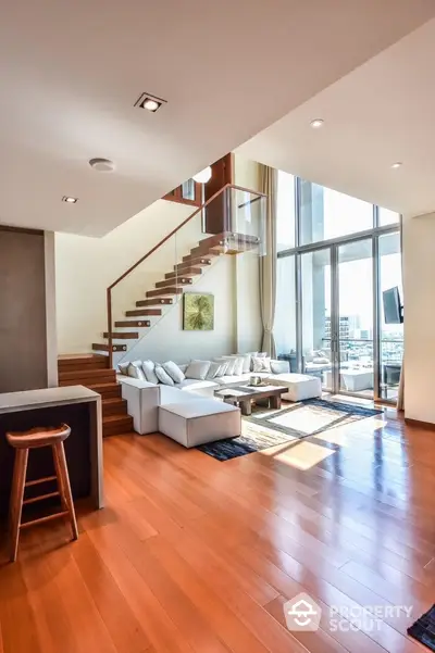 Luxurious modern living room with high ceilings and large windows offering stunning city views.