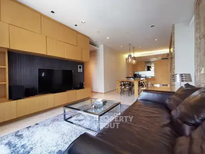 Modern living room with sleek leather sofa and open kitchen layout