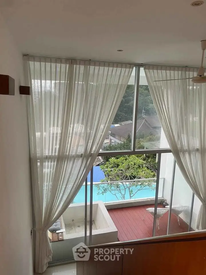 Luxurious apartment with floor-to-ceiling windows and pool view, featuring elegant curtains and modern design.