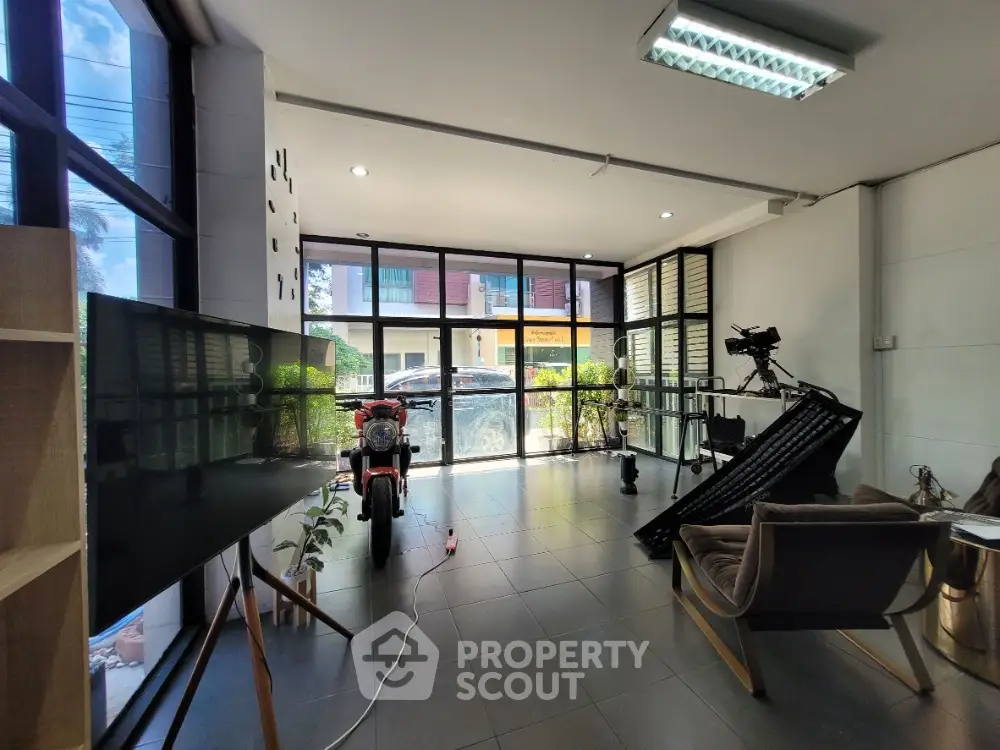 Modern living room with large windows and sleek furniture, showcasing a stylish urban vibe.