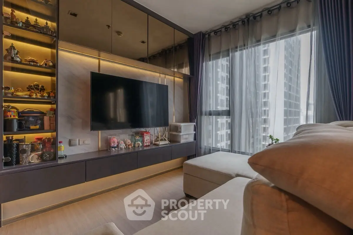 Modern living room with large TV and floor-to-ceiling windows in a high-rise apartment.