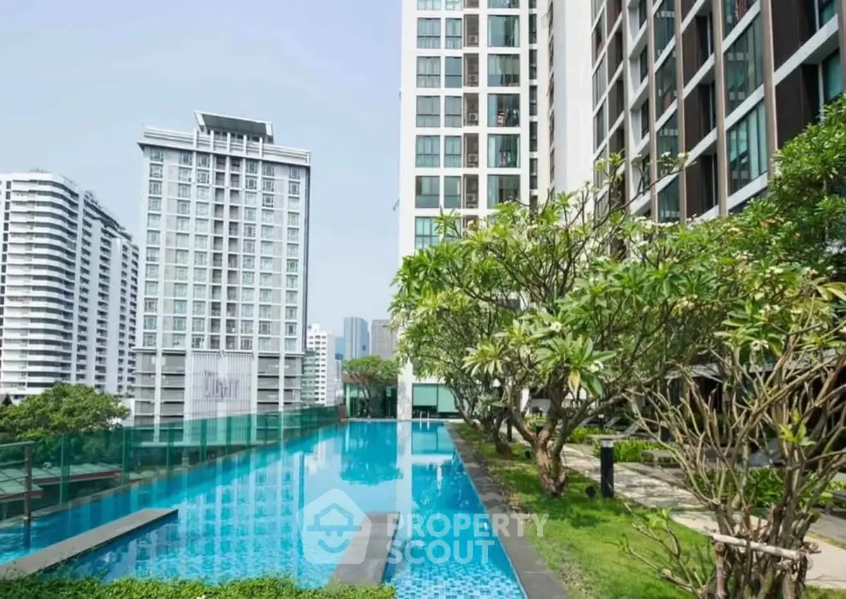 Luxurious condominium with stunning pool and lush garden view in urban setting.