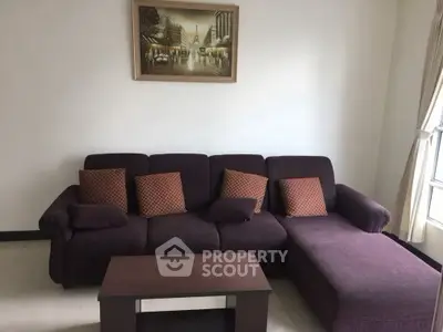 Cozy living room with plush purple sofa and elegant wall art