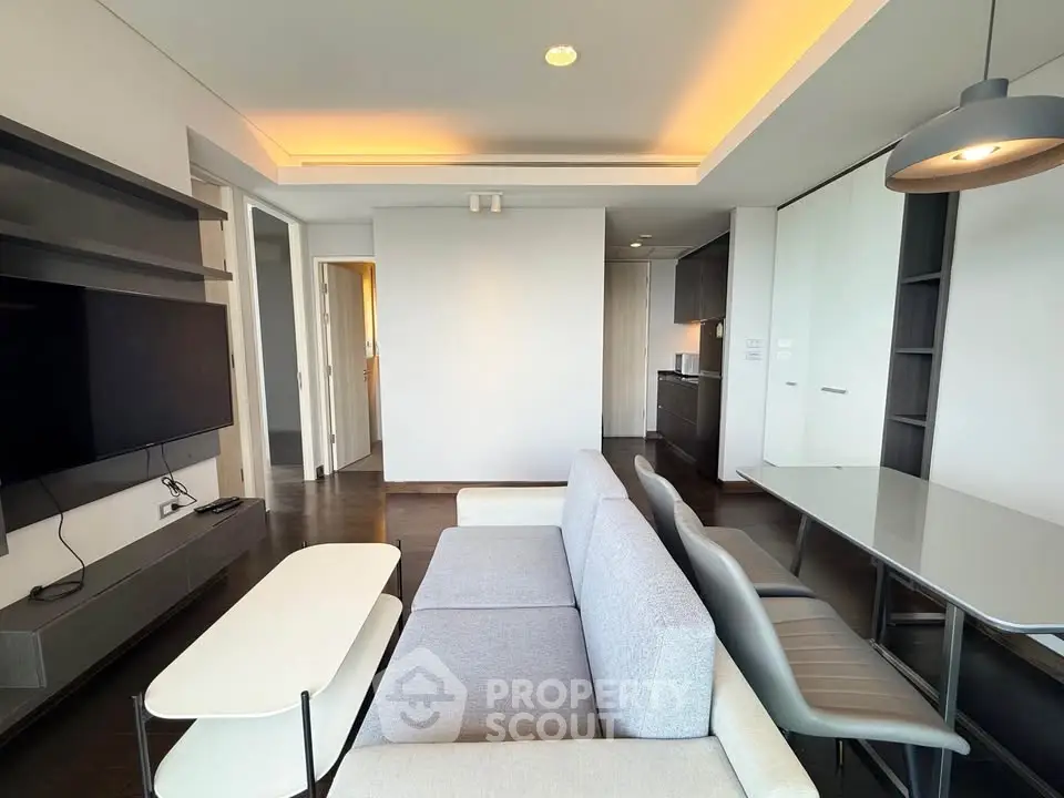 Modern living room with sleek furniture and open kitchen layout in a stylish apartment.