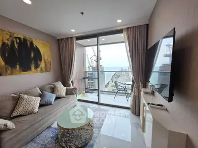 Luxurious living room with stunning balcony view of the city and ocean, featuring modern decor and elegant furnishings.
