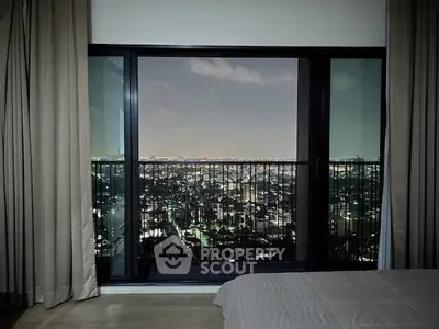 Stunning city view from a high-rise bedroom with floor-to-ceiling windows.